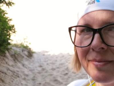 Kobieta z kijkami do Nordic Walkingu na plaży