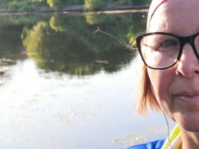 Kobieta z kijkami do Nordic Walkingu nad jeziorem